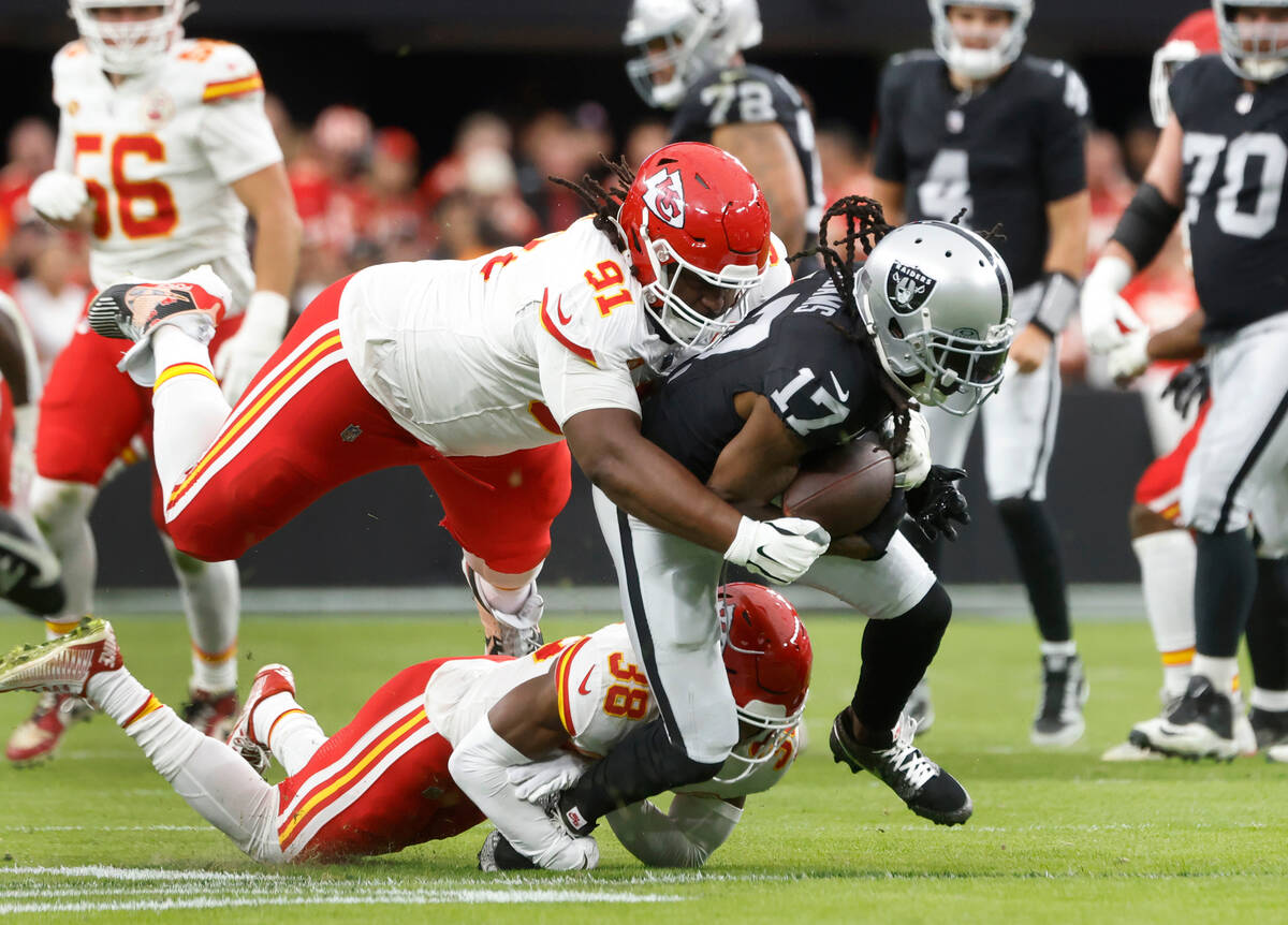 Raiders wide receiver Davante Adams (17) is takedown by Kansas City Chiefs defensive tackle Der ...