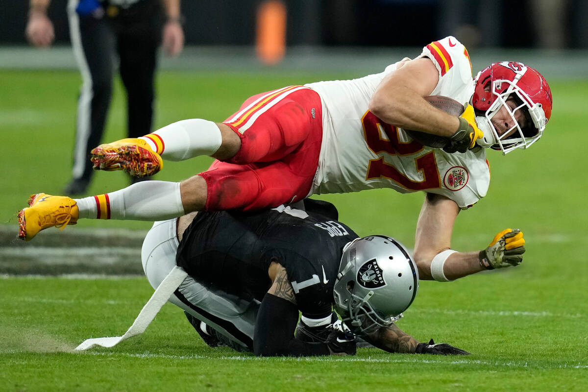 Kansas City Chiefs tight end Travis Kelce, top, is tackled by Las Vegas Raiders safety Marcus E ...