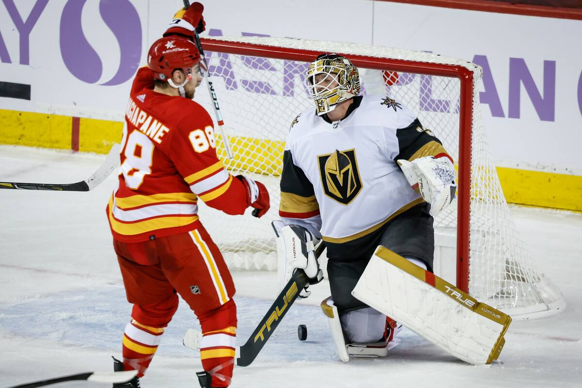 Vegas Golden Knights goalie Adin Hill, right, reacts as Calgary Flames forward Andrew Mangiapan ...