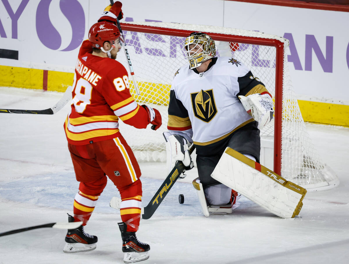 Vegas Golden Knights goalie Adin Hill, right, reacts as Calgary Flames forward Andrew Mangiapan ...