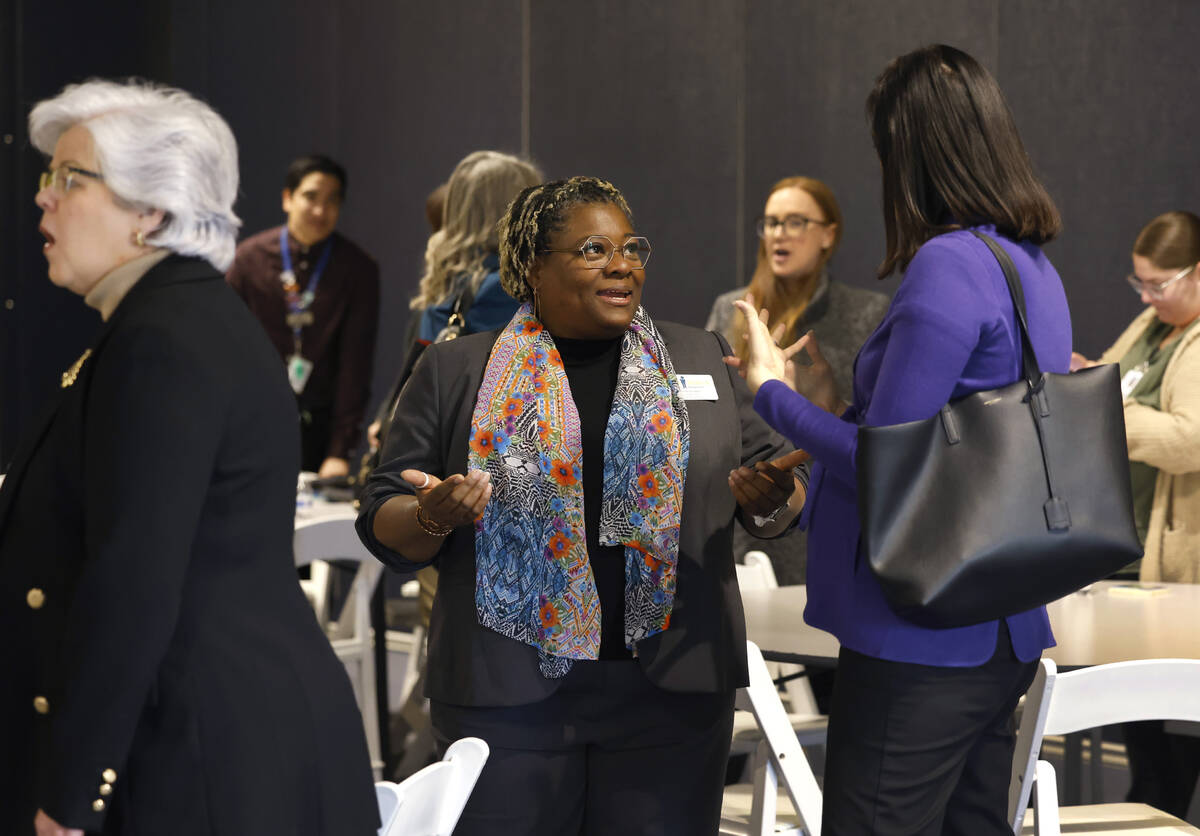 Dana Roseman, center, senior director of Boys Town, chats with attendees after Jhone M. Ebert, ...