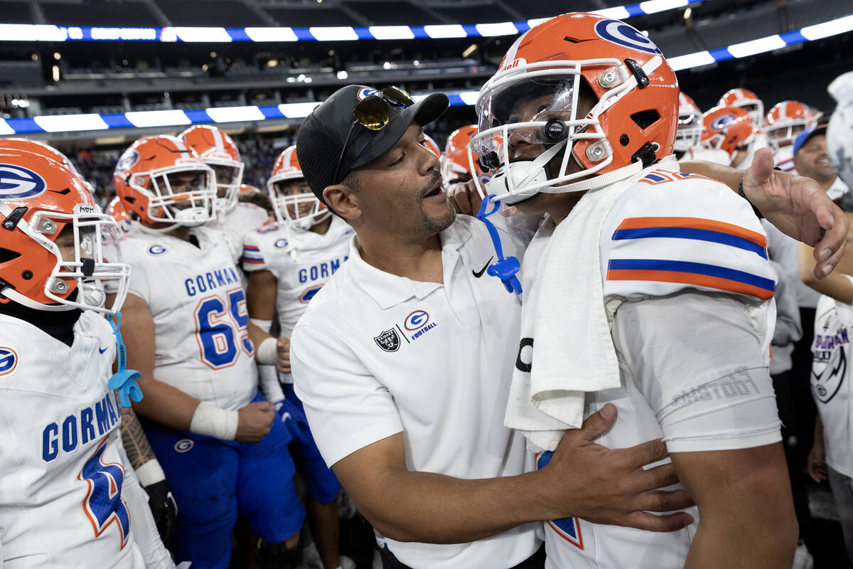 Bishop Gorman head coach Brent Browner congratulates senior quarterback Micah Alejado on their ...