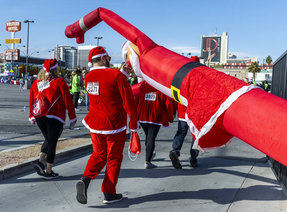 After losing some power, a Santa Claus air dancer is pushed upward as participants finish at th ...