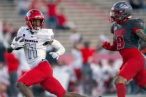 UNLV's Ricky White, left, looks back at New Mexico's Noa Pola-Gates, right, while running a rec ...