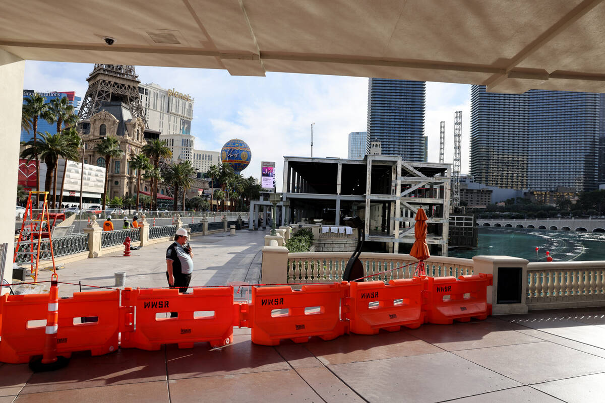 Workers dismantle Formula One grandstands and luxury boxes at the Bellagio fountains on the Str ...