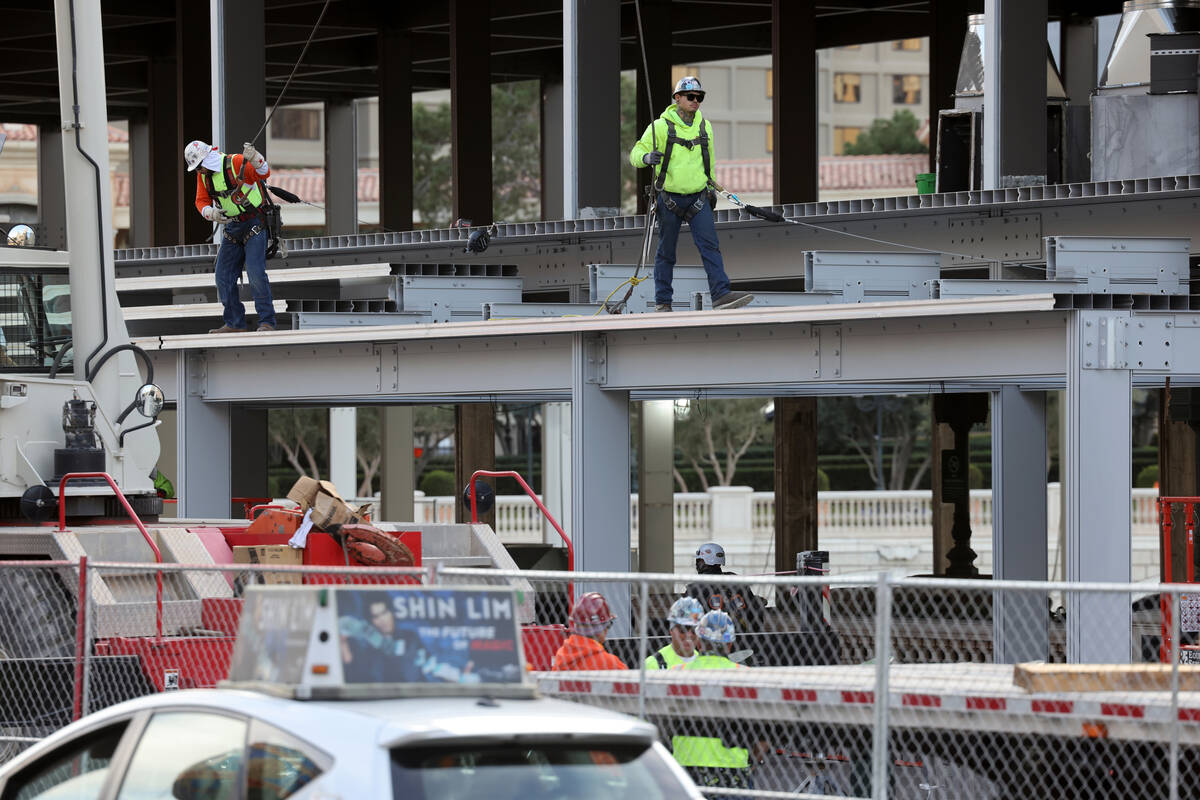 Workers dismantle Formula One grandstands and luxury boxes at the Bellagio fountains on the Str ...