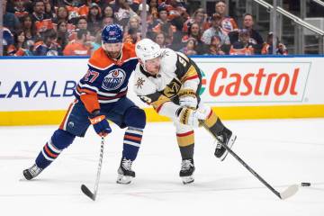 Vegas Golden Knights' Jack Eichel (9) and Edmonton Oilers' Brett Kulak (27) battle for the puck ...
