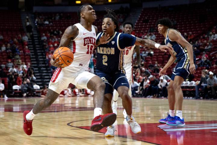 UNLV Rebels guard Luis Rodriguez (15) drives toward the hoop against Akron Zips guard Greg Trib ...