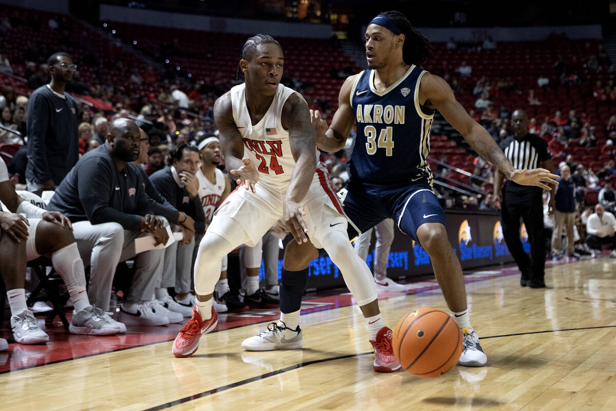 UNLV Rebels guard Jackie Johnson III (24) passes the ball with pressure from Akron Zips guard N ...