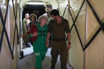 Ruth Munder, a released Israeli hostage, walks with an Israeli soldier shortly after her arriva ...