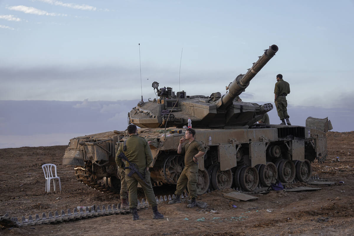 Israeli soldiers work on a tank near the border with the Gaza Strip, southern Israel, Tuesday, ...