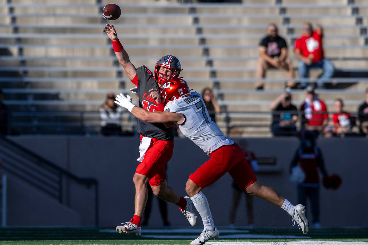 New Mexico quarterback Dylan Hopkins gets rid of the ball before being hit by UNLV's Jackson Wo ...