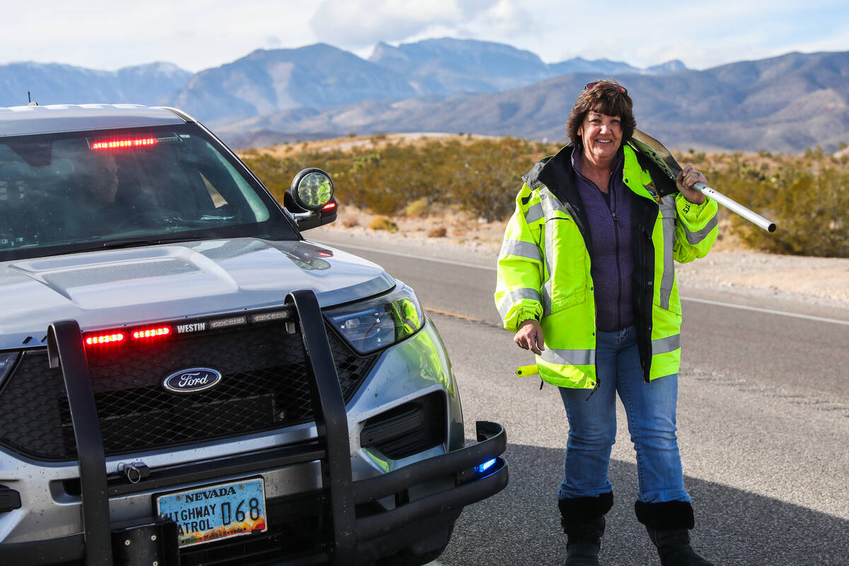 Donna Thompson helps put up signs displaying the names of victims who have lost their lives to ...