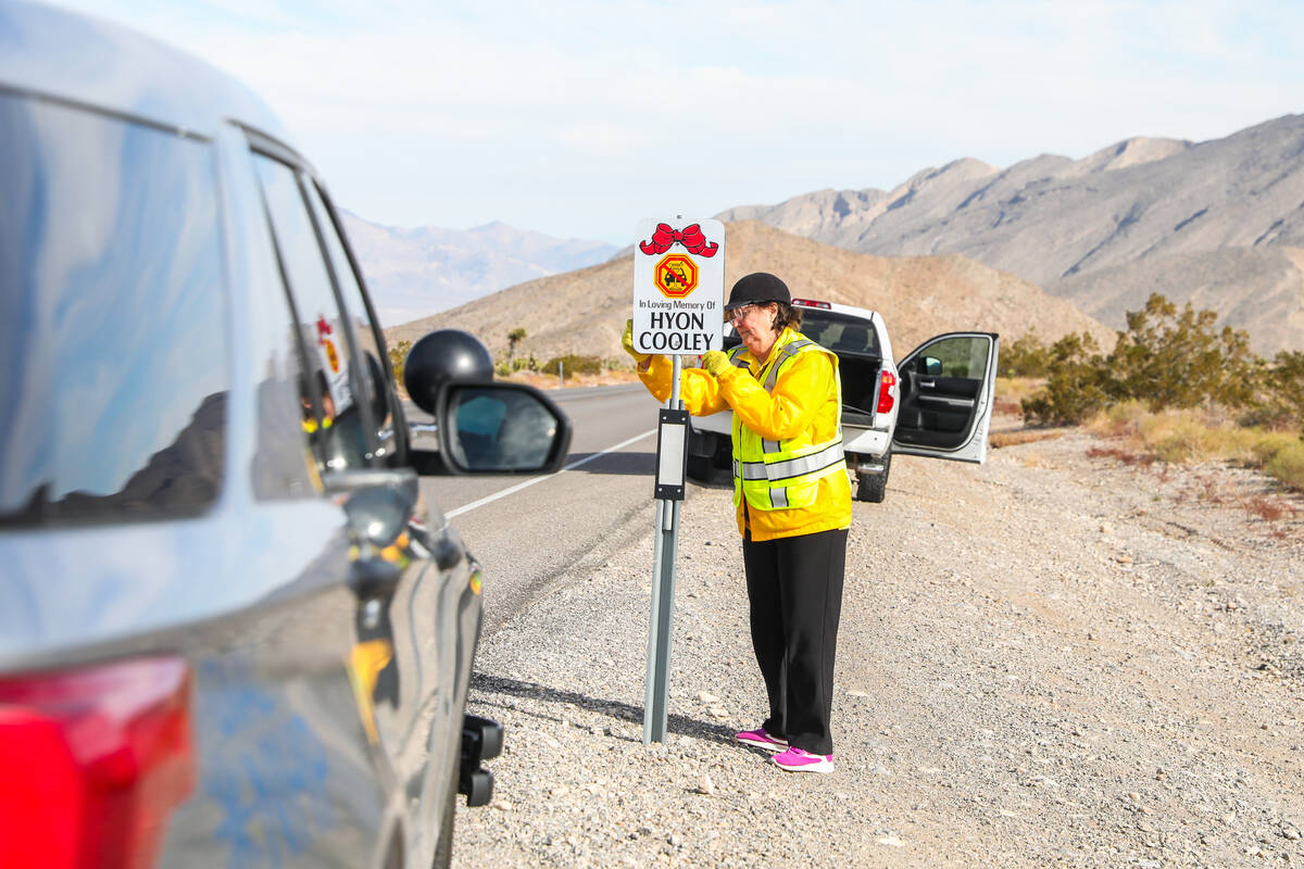 Melodye McGroarty helps put up signs displaying the names of victims who have lost their lives ...