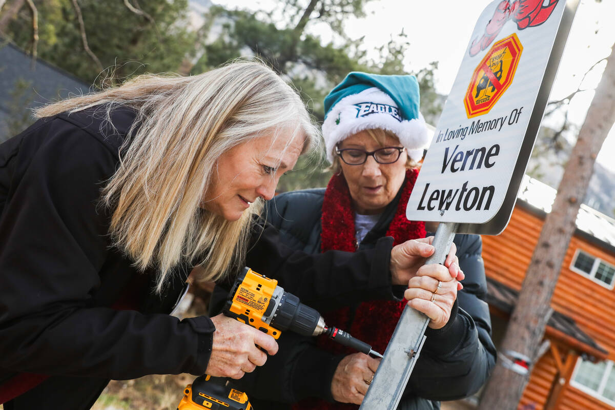Diane Malone, left, and Joan Eddowes help put up signs displaying the names of victims who have ...