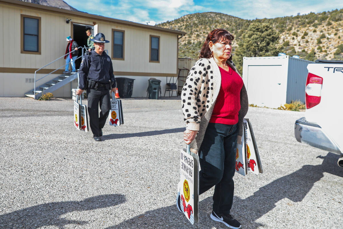 Maria Ramirez helps put up signs displaying the names of victims who have lost their lives to d ...