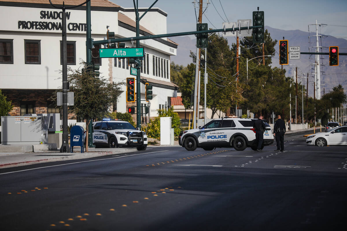 Police wait on the street of the coroner’s office for the procession of one of the bodies of ...