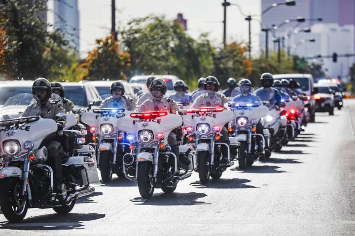 A police procession for a slain Nevada Highway Patrol Trooper moves towards the coroner’ ...