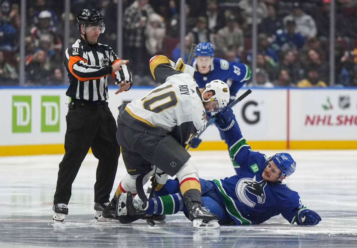 Vancouver Canucks' Teddy Blueger falls after taking a faceoff against Vegas Golden Knights' Nic ...