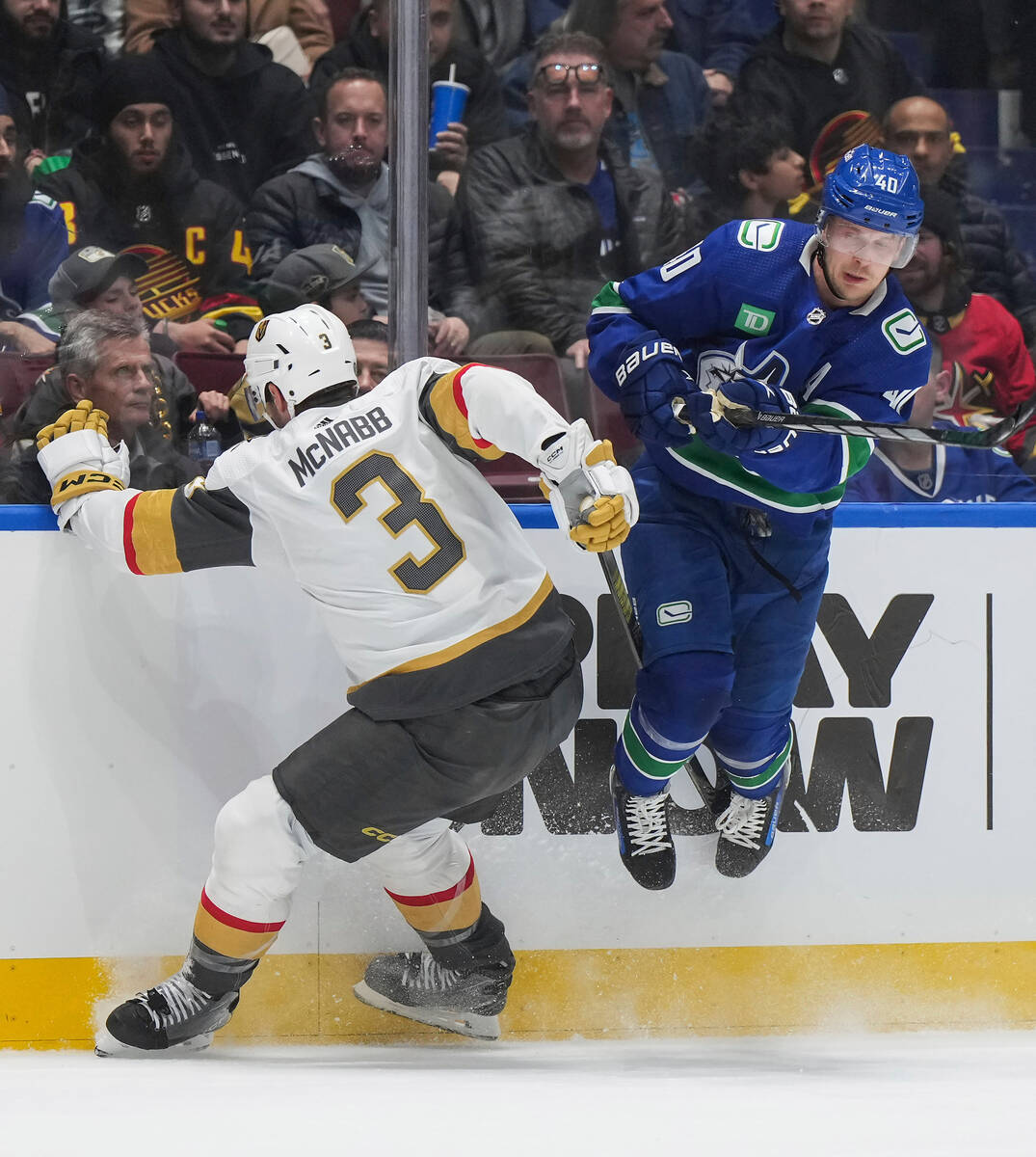 Vancouver Canucks' Elias Pettersson, right, avoids a check by Vegas Golden Knights' Brayden McN ...