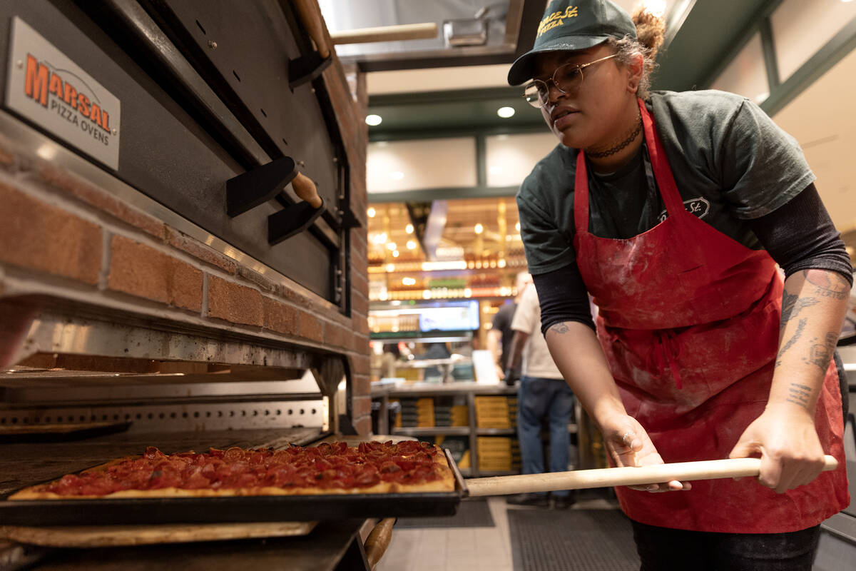 Pizza maker Aiyiko Batiste removes a pepperoni pie from the oven at Prince Street Pizza during ...