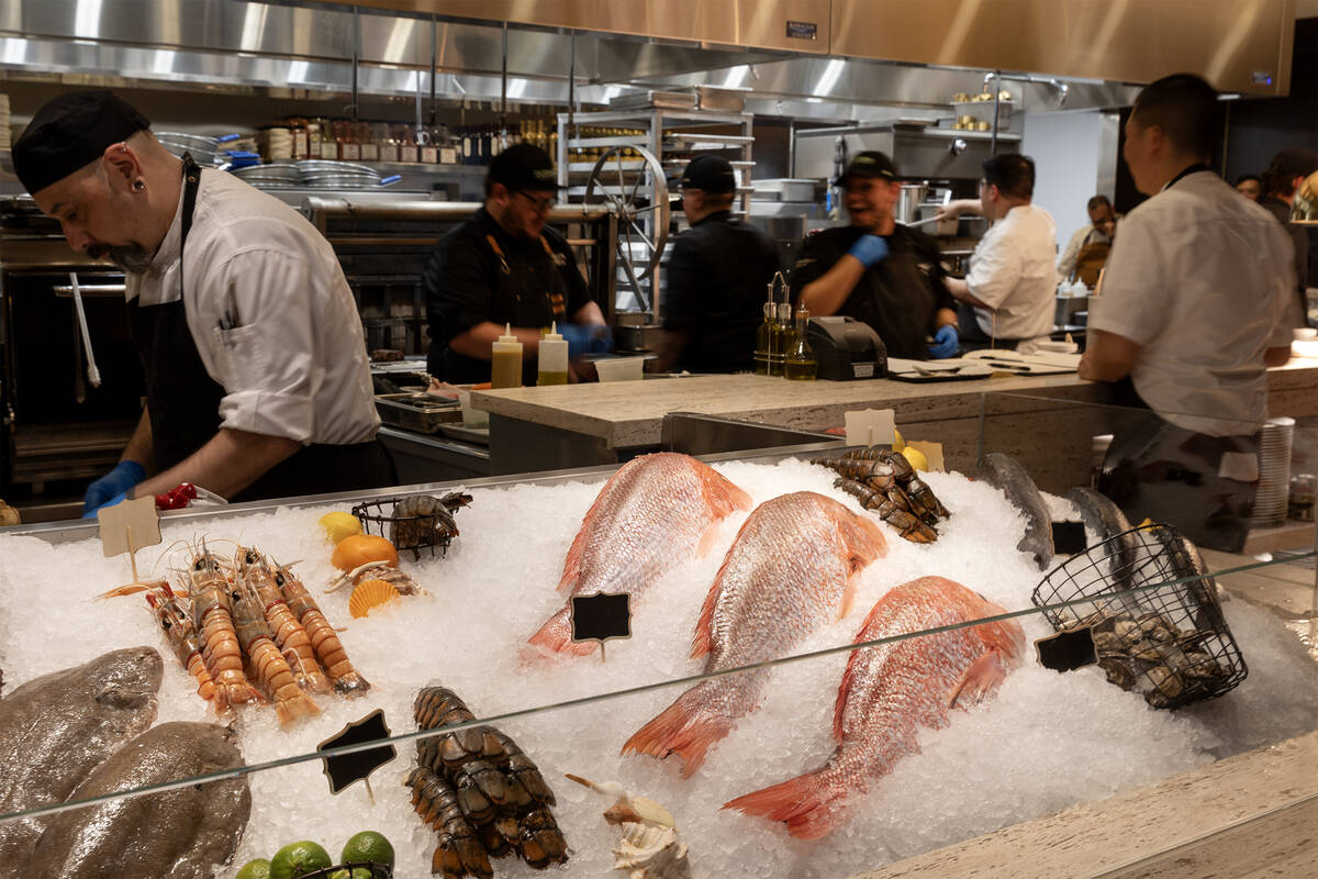 The kitchen bustles behind iced seafood at Nicco's Prime Cuts & Fresh Fish during a friends ...
