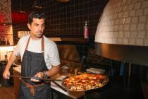 World champion pizza maker Michael Vakneen pulls a pizza from the oven at his new restaurant, D ...