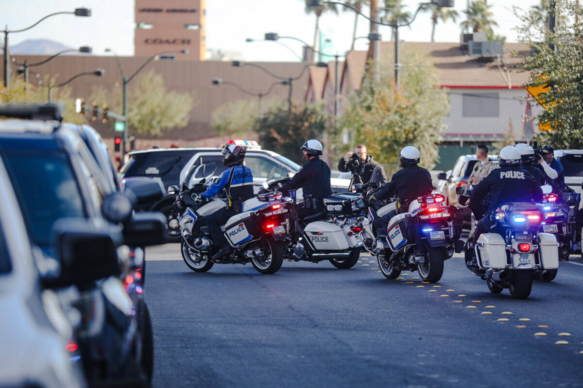 A police procession for a slain Nevada Highway Patrol Trooper moves towards the coroner’ ...