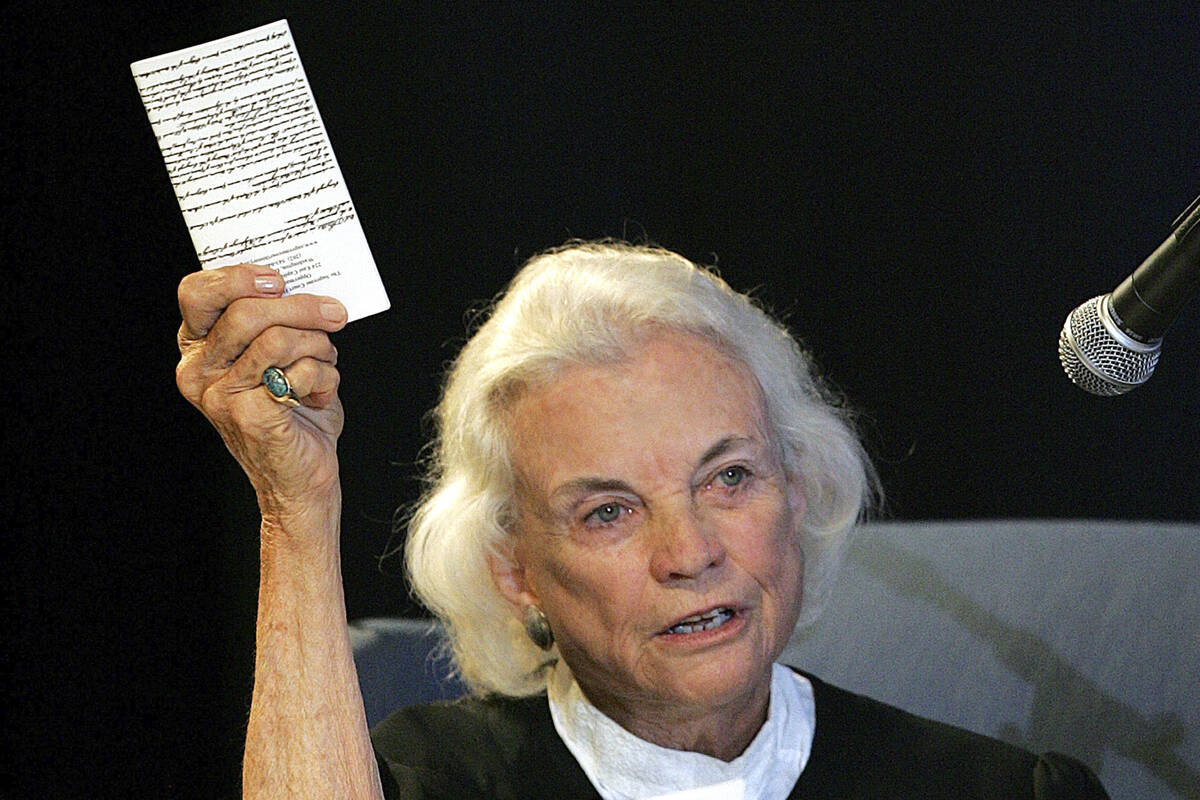 FILE - U.S. Supreme Court Justice Sandra Day O'Connor hold up a copy of the U.S. constitution t ...