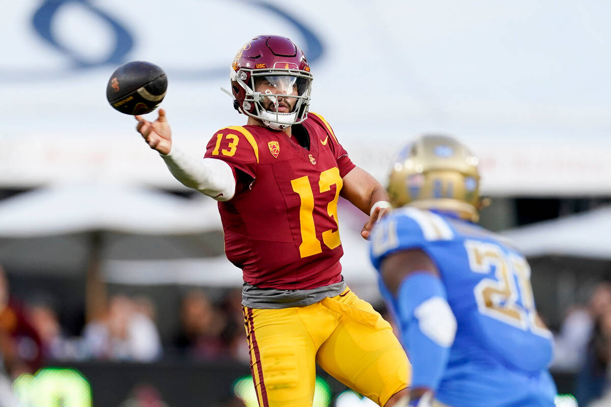 Southern California quarterback Caleb Williams, left, throws a pass as UCLA linebacker JonJon V ...