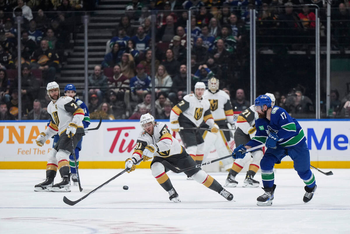 Vegas Golden Knights' Jonathan Marchessault reaches for the puck in front of Vancouver Canucks' ...