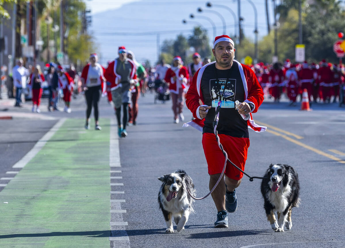 Participants in the 5K run head to the finish line during the Las Vegas Great Santa Run through ...
