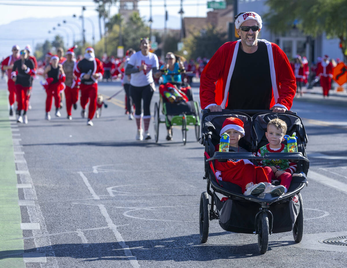 Participants in the 5K run head to the finish line during the Las Vegas Great Santa Run through ...