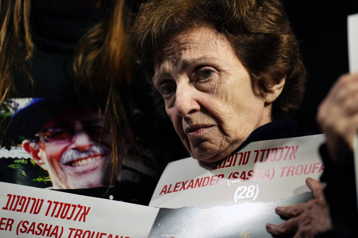 Irena Tati holds a picture of her grandson, Alexander, held by Hamas in Gaza, during a demonstr ...