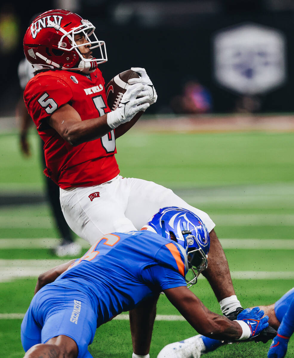 UNLV running back Vincent Davis Jr. (5) falls as he runs into Boise State players during the Mo ...