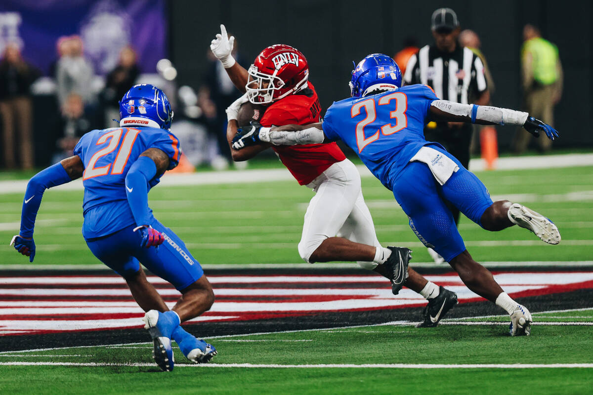 UNLV running back Vincent Davis Jr. (5) dodges Boise State safety Seyi Oladipo (23) and Boise S ...