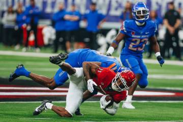 UNLV wide receiver Ricky White (11) is taken down with the ball by a Boise State defender durin ...