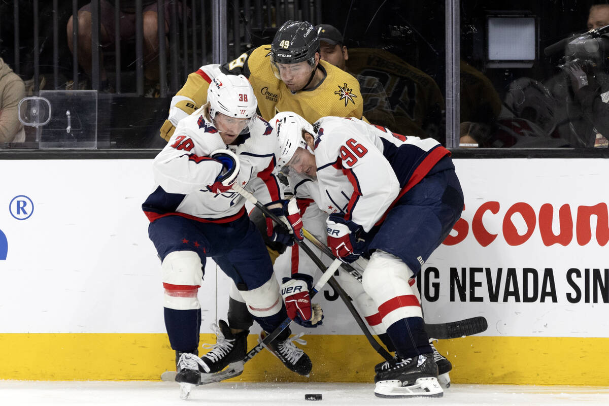 Golden Knights center Ivan Barbashev (49) battles for the puck with Capitals defenseman Rasmus ...