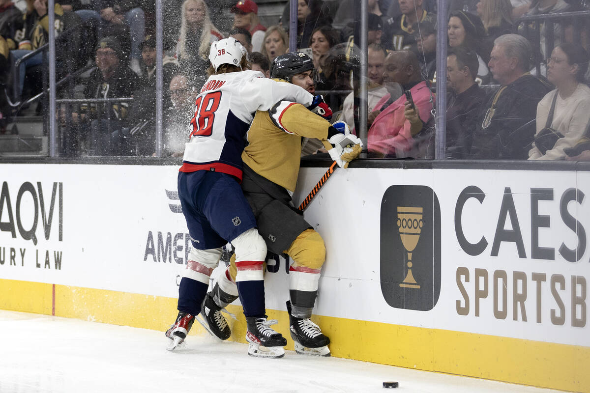 Golden Knights left wing William Carrier (28) takes a hit from Capitals defenseman Rasmus Sandi ...