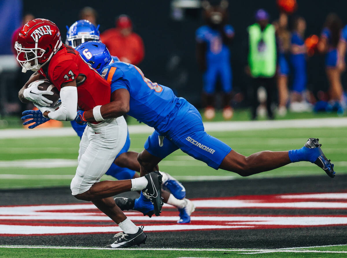 UNLV wide receiver Ricky White (11) runs with the ball as Boise State cornerback Jaylen Clark ( ...