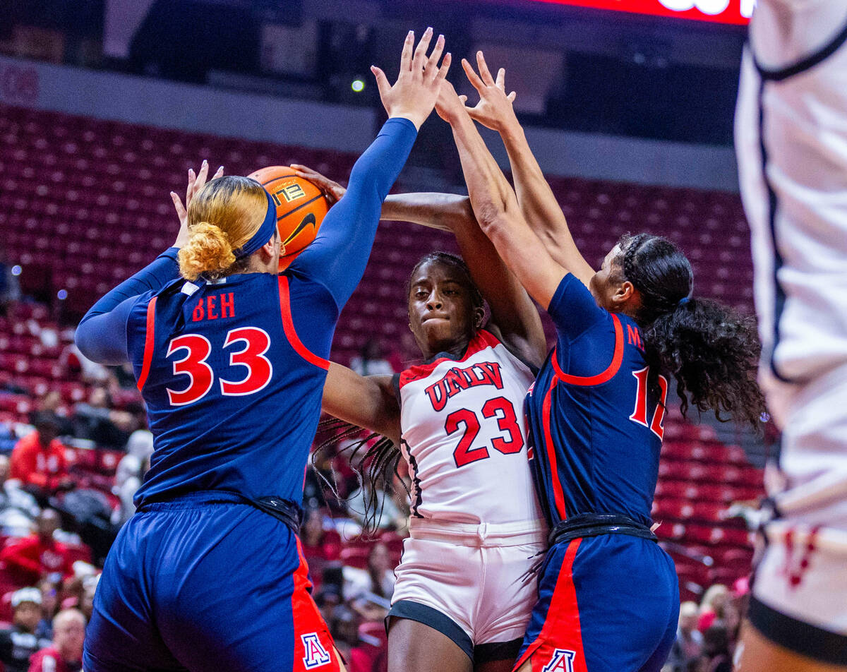 UNLV Lady Rebels center Desi-Rae Young (23) looks to pass between Arizona Wildcats forward Isis ...