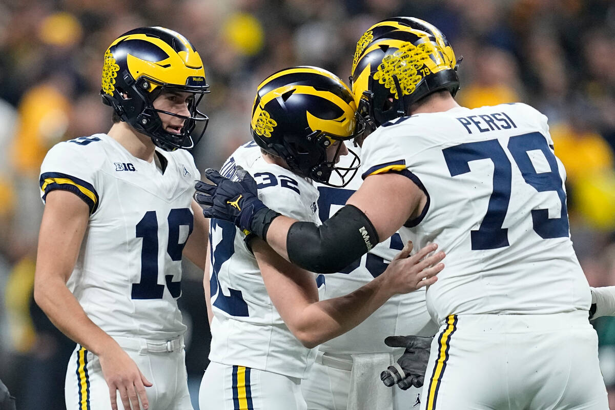 Michigan place-kicker James Turner (32) celebrates with teammates after kicking a field goal du ...