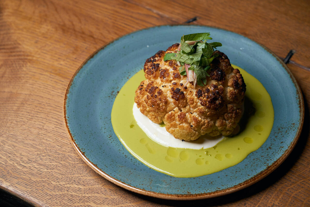 Roasted cauliflower with goat cheese and shishito-herb vinaigrette is a signature dish at KYU, ...