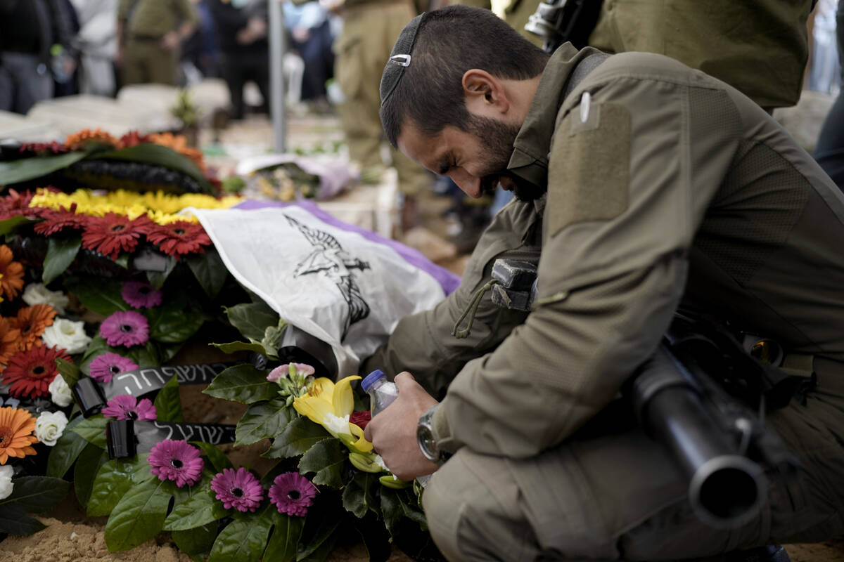 An Israeli soldier reacts next to the grave of reservist Master Sgt. Gil Daniels during his fun ...