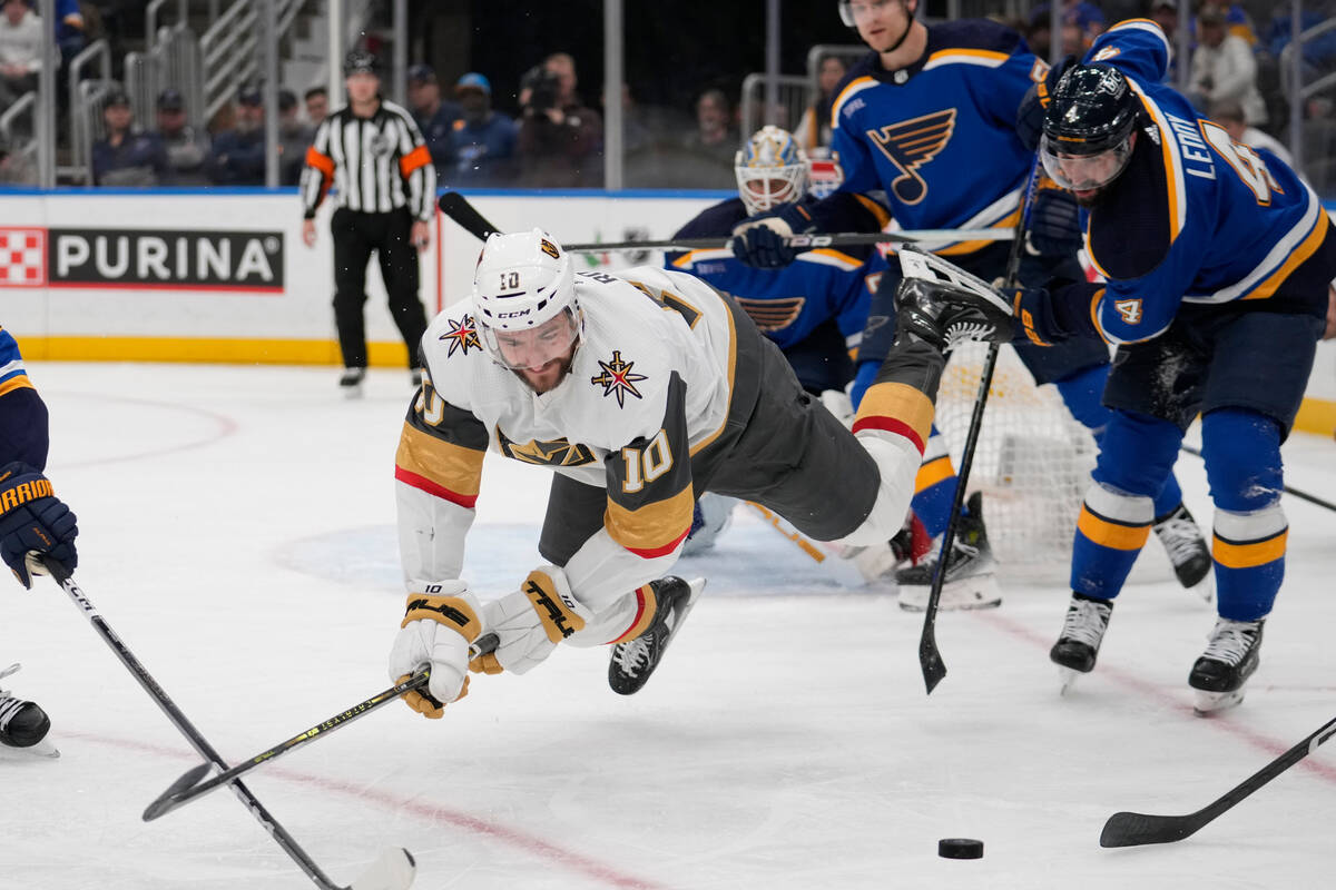 Vegas Golden Knights' Nicolas Roy (10) reaches for a loose puck as St. Louis Blues' Nick Leddy ...