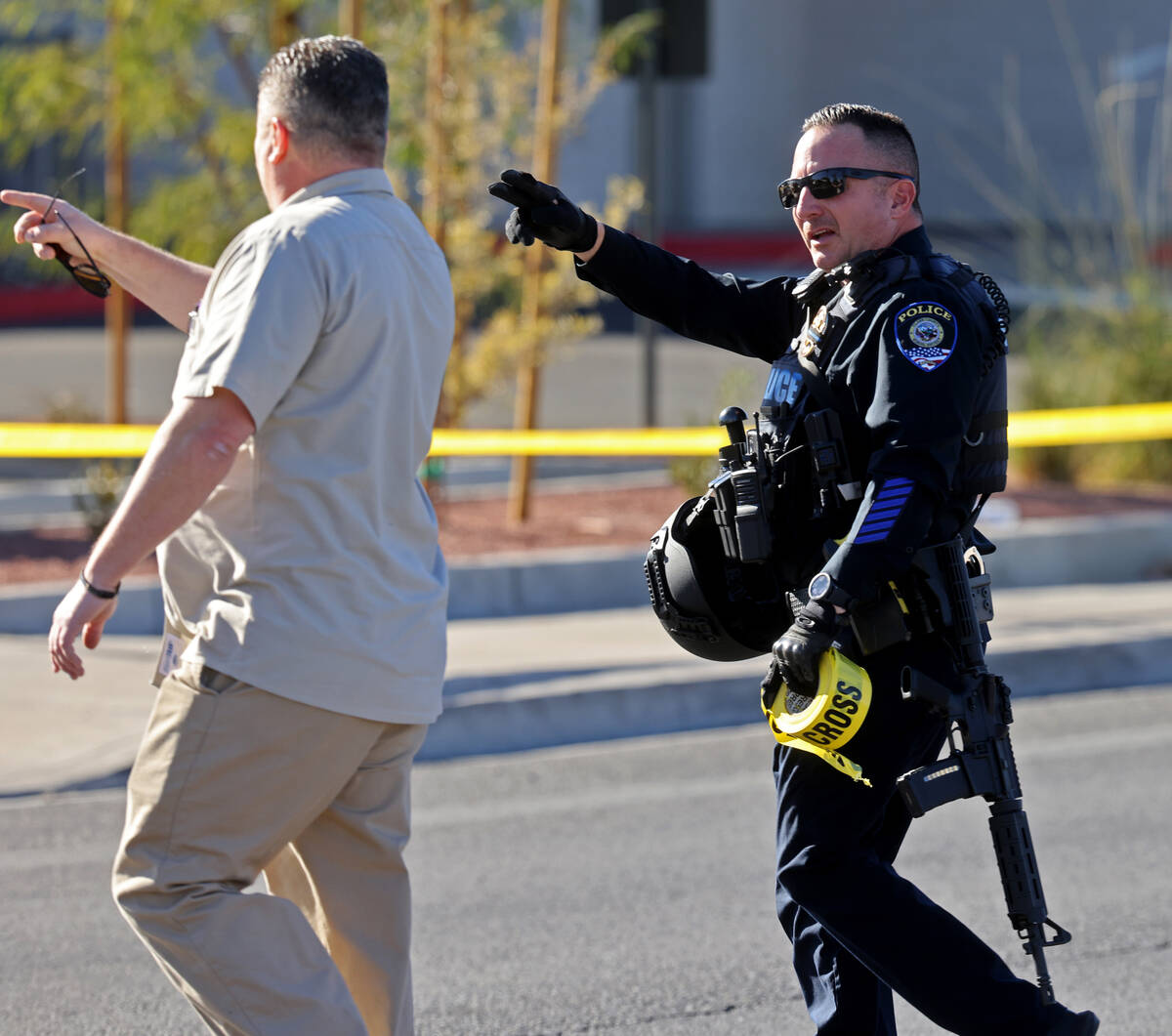 Police give directions around crime scene tape on Harmon Avenue near Maryland Parkway after a s ...
