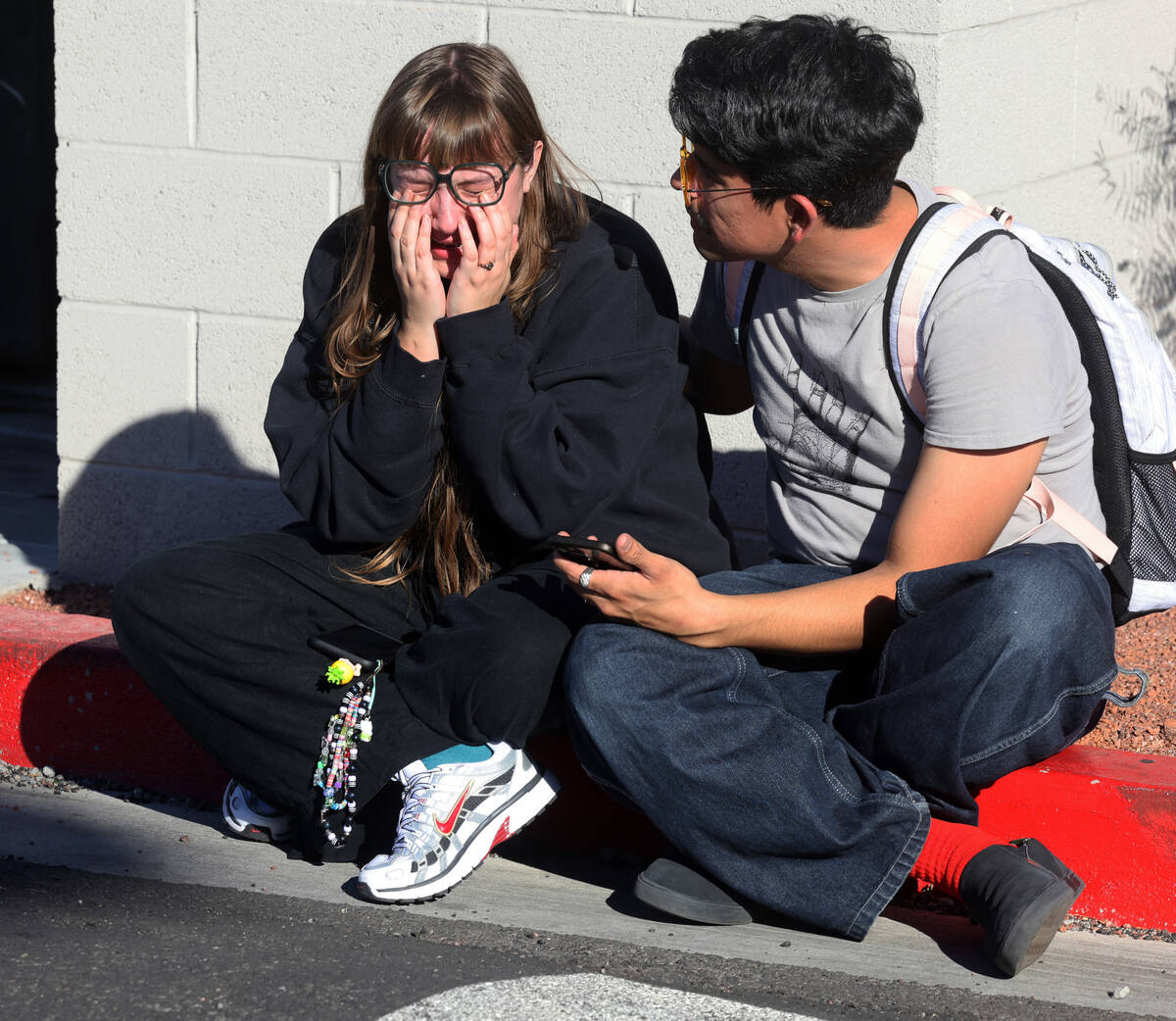 Amanda Perez is comforted by fellow student Alejandro Barron near Maryland Parkway following a ...
