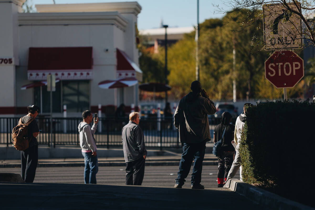 People make phone calls and film during police presence during a shooting on the UNLV campus on ...