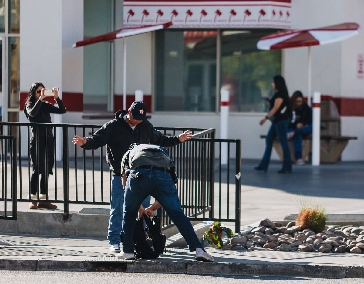 A person has their bag searched at the scene of a shooting on the UNLV campus on Wednesday, Dec ...