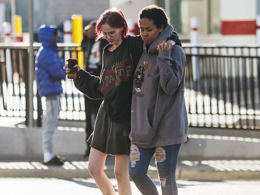 Students walk through the scene of a shooting on the UNLV campus on Wednesday, Dec. 6, 2023, in ...